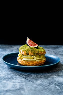 Pistachio Krem ve Fig 'li Paris Brest / Göğüs Eclair. Geleneksel Organik Tatlıları Servis Etmeye ve Yemeye Hazır.