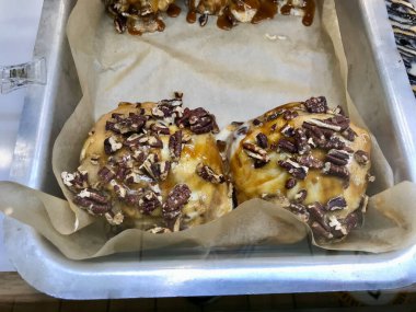Tray 'deki Şekerli Çörek Showcase of Dessert Shop / Cinnabon' da satılık Tarçınlı Çörekler. Hizmet ve Yemeye Hazır.
