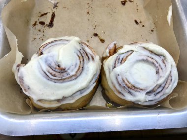 Tray 'deki Şekerli Çörek Showcase of Dessert Shop / Cinnabon' da satılık Tarçınlı Çörekler. Hizmet ve Yemeye Hazır.