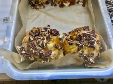 Tray 'deki Şekerli Çörek Showcase of Dessert Shop / Cinnabon' da satılık Tarçınlı Çörekler. Hizmet ve Yemeye Hazır.