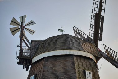 Almanya 'nın Woldegk kentindeki Muehlenberg' deki tarihi yel değirmeninde, kiremit, kuyruk değirmeni ve yelkenli olan ahşap yel değirmeni kapağının yakın plan detayları..