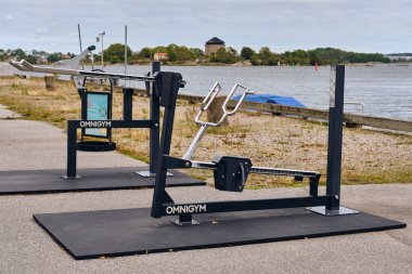 Karlskrona, İsveç; 15 Eylül 2025: Karlskrona Quay Parkı 'ndaki açık hava spor salonu ekipmanları ve adadaki kale manzarası.