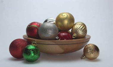 Beyaz arka planda ahşap bir top kasesi ve üzerine de bazı süsler dökülüyor. Konu metin için boş alanı olan beyaz bir arkaplan üzerinde. 