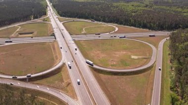 Yüksek açılı insansız hava aracı birden fazla şeritli ve üstgeçitli geniş bir otoyol kavşağını yakalıyor. Geniş yol ağı geniş çam ormanları ve açık çim alanlarıyla çevrilidir..