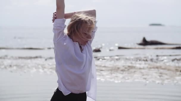 Blonde fille sensuellement danser sur un fond de la mer en blanc et noir vêtements — Video