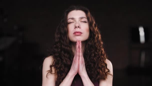 Close-up de uma jovem com cabelos longos e encaracolados, respiração profunda ao fazer ioga. Câmera zoom em câmera lenta 4K. Menina em um estado de relaxamento — Vídeo de Stock