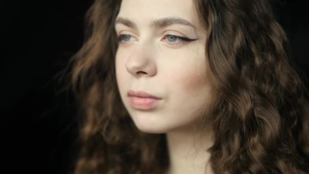 Uma menina calma e meditativa balança o cabelo e sorri timidamente. Close-up em Slowmo — Vídeo de Stock