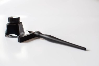 Eski tükenmez kalem ve mürekkep şişesi üzerinde beyaz arka plan izole. Vintage hat kalem ve mürekkep şişesi. Seçici odak. Yakın çekim.