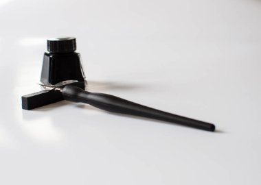 Eski tükenmez kalem ve mürekkep şişesi üzerinde beyaz arka plan izole. Vintage hat kalem ve mürekkep şişesi. Seçici odak. Yakın çekim.