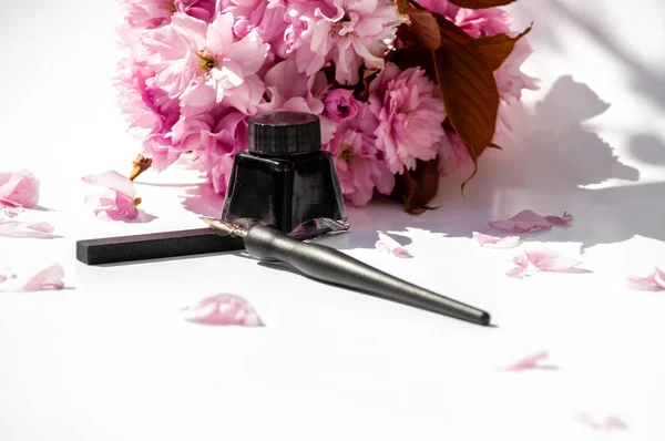 흰색 배경에 오래 된 잉크 펜과 잉크 병. 빈티지 서예 펜과 잉크 병. 검은 잉크와 벚꽃 나뭇 가지 — 스톡 사진