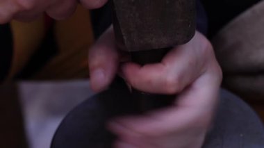 Geleneksel madeni para yapma süreci. Eski paraları basmak için iki metal pul. Kalıplardaki ayrıntılı dairesel desenler açıkça görülüyor, arka planda çeşitli madeni paralarla dolu ahşap bir kutu var..