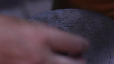 Geleneksel madeni para yapma süreci. Eski paraları basmak için iki metal pul. Kalıplardaki ayrıntılı dairesel desenler açıkça görülüyor, arka planda çeşitli madeni paralarla dolu ahşap bir kutu var..