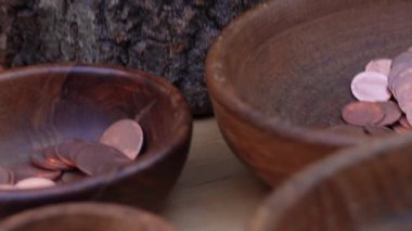 Geleneksel madeni para yapma süreci. Eski paraları basmak için iki metal pul. Kalıplardaki ayrıntılı dairesel desenler açıkça görülüyor, arka planda çeşitli madeni paralarla dolu ahşap bir kutu var..