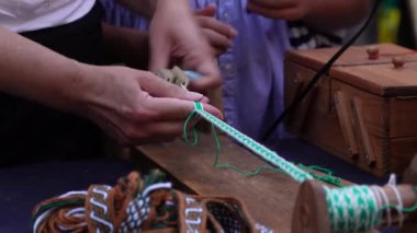 El işi, Geleneksel Hobi Yetenekleri. Kalıplı kurdele dokumaya odaklanmış bir adamın elleri. Geleneksel zanaat ve yaratıcılık. 