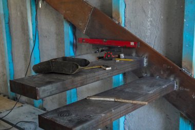 Cantilever merdiveni. Metal çerçeve ve çeşitli inşaat aletleriyle inşa halinde olan modern bir Cantilever merdiveni..