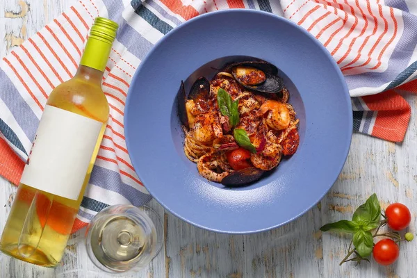 pasta with seafood and a bottle of white wine