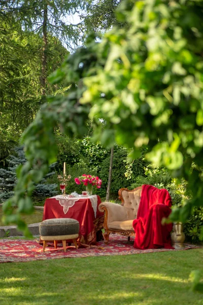 antique furniture in the summer garden with a glass of wine