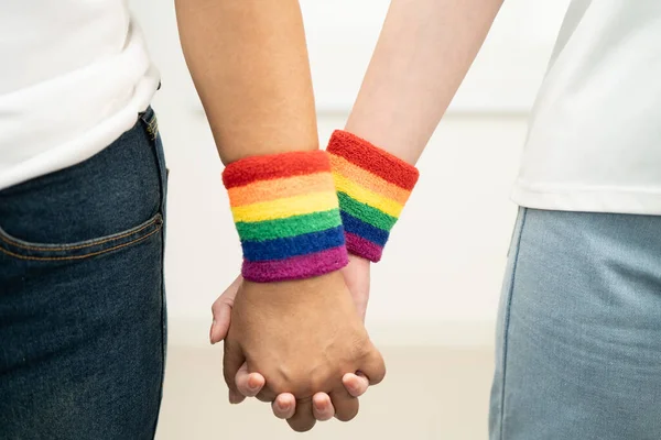 Gökkuşağı bilekliği takan Asyalı LGBT çifti..