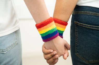 Gökkuşağı bilekliği takan Asyalı LGBT çifti..