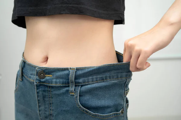 Genç Asyalı kadın, bol bol pantolon giyerek kilo veriyor..