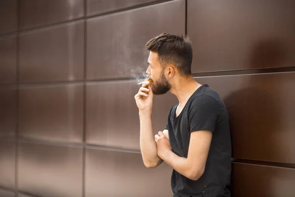 Ένα Νεαρό Όμορφος Λευκό Γενειοφόρος Άνδρας Μαύρο Shirt Καπνίζει Ένα — Φωτογραφία Αρχείου