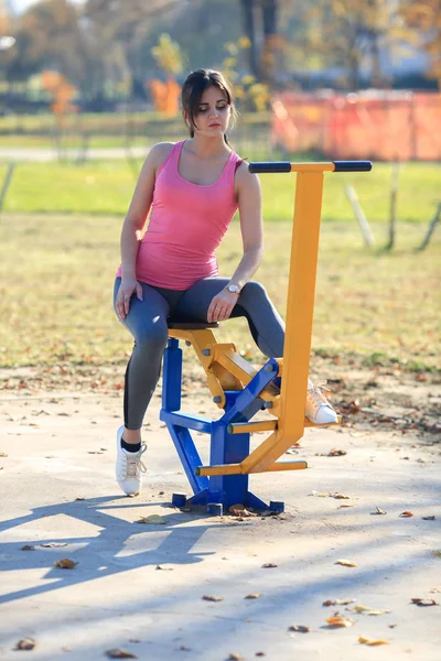Young Athletic Girl Sitting Sports Simulator Street Playground Autumn — Stock Photo, Image
