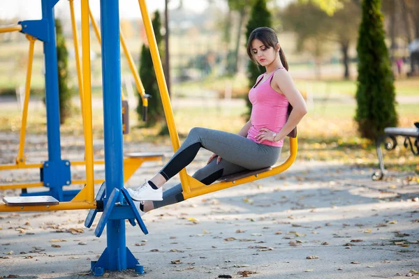 Chica Atlética Joven Está Sentado Simulador Deportes Parque Infantil Calle — Foto de Stock