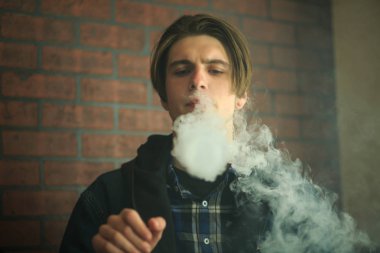 Vape genç. Barda elektronik sigara içen genç yakışıklı adamın portresi. Sağlık için zararlı kötü alışkanlık. Vaping etkinliği.