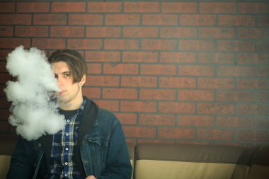 Vape genç. Barda elektronik sigara içen genç yakışıklı adamın portresi. Sağlık için zararlı kötü alışkanlık. Vaping etkinliği.
