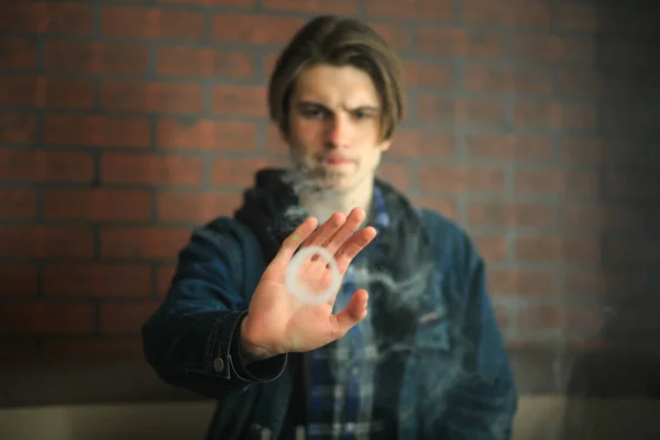 Vape genç. Barda elektronik sigara içen genç yakışıklı adamın portresi. Sağlık için zararlı kötü alışkanlık. Vaping etkinliği.