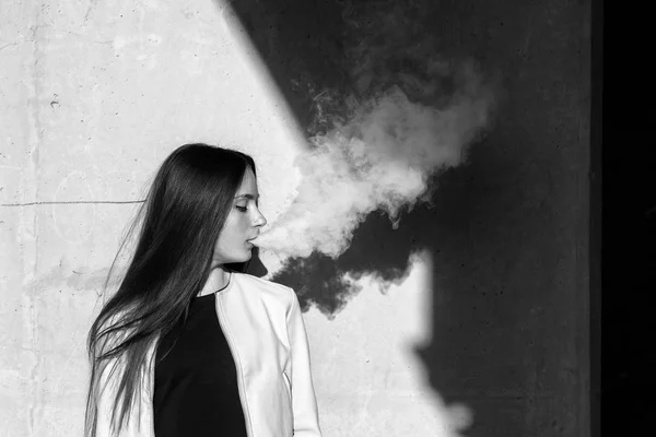 流浪少年夏天 穿着休闲装的可爱女孩在户外的墙边抽着一支电子香烟 有害健康的坏习惯 血管活动 黑白相间 — 图库照片