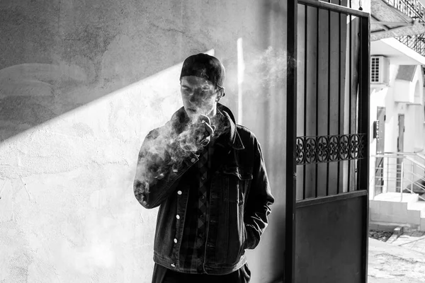 Vape Genç Lkbaharda Sokakta Elektronik Sigara Içen Bir Şapkalı Genç — Stok fotoğraf