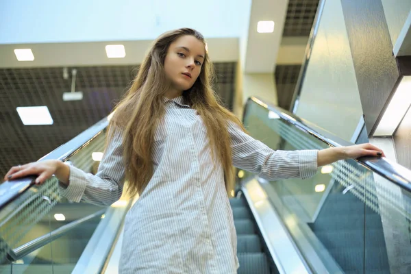 Bir Alışveriş Merkezinde Yürüyen Merdiven Üzerinde Bir Gömlek Uzun Saçlı — Stok fotoğraf