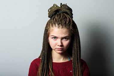 Afrika örgü ve Maroon kazak ile öfkeli duygusal genç güzel beyaz genç kız çekim yakın. Duygu kartı.