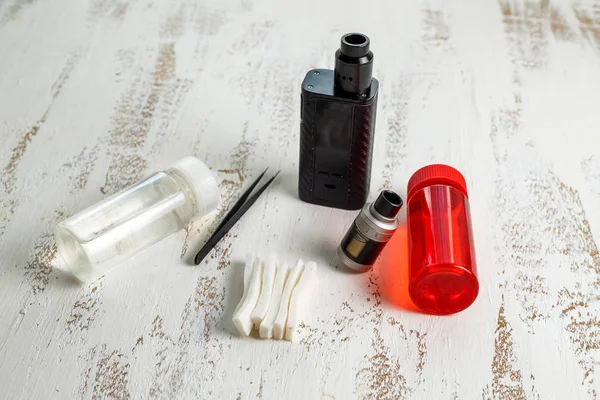 Vape 电子烟和罐装电子液体放在一张轻巧的木桌上 — 图库照片