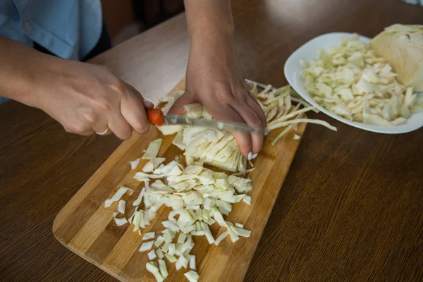 女性双手在厨房的桌子上的木板上切白菜 适当的营养 — 图库照片