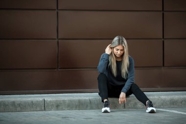 Sevimli Genç kız sokakta modern kentsel arka plan önünde olumlu duygular gösterir. Yaşam tarzı.