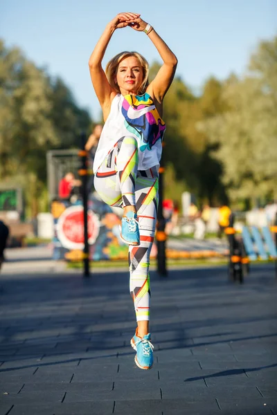 夏の晴れた日に公園のストリートスポーツグラウンドでトラックスーツを着た美しい成熟した女性 ストリートスポーツグラウンドでのフィットネス — ストック写真