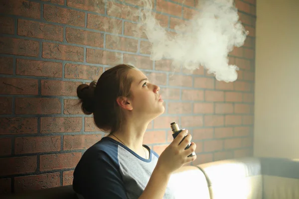 Sorunlu cildi olan Vape genç. Barda elektronik sigara içen genç sevimli kız portresi. Sağlık için zararlı kötü alışkanlık. Vaping etkinliği.