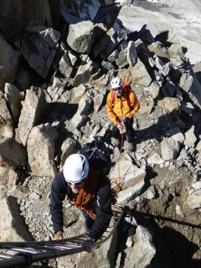 dağ rehberi ve istemci bir merdivene tırmanma rotalarını Chamonix Mont Blanc yakınındaki çıkmak için hazır olun
