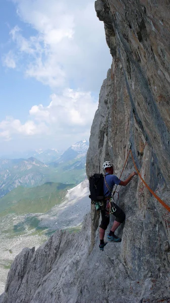 男性登山クロスタース近くスイス アルプスのルートを登る急な岩の上 — ストック写真