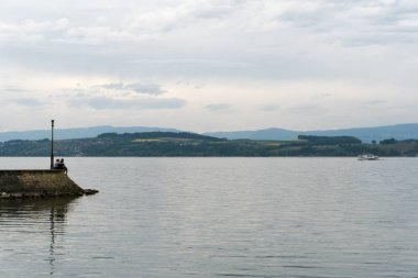 uzun bir iskele sonunda oturan ve muhteşem bir göl ve dağ manzarası akşamları manzaranın genç aşıklar
