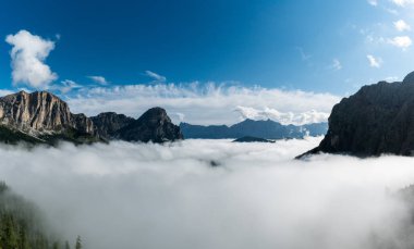 Val Gardena dağ zirveleri ile İtalyan Dolomites içinde ve kalın bulut örtüsü altında geç sonbaharda mavi gökyüzünde vadilerde Panorama dağ manzarası