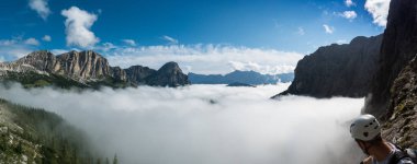 Val Gardena dağ zirveleri ile İtalyan Dolomites içinde ve kalın bulut örtüsü geç sonbaharda mavi gökyüzünde ve kaya tırmanma enjoing görünümü altındaki vadilerde Panorama dağ manzarası