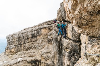 Genç erkek dağcı bir dik ve savunmasız Via Ferrata İtalyanca Dolomites South Tyrol Alta Badia içinde üzerinde