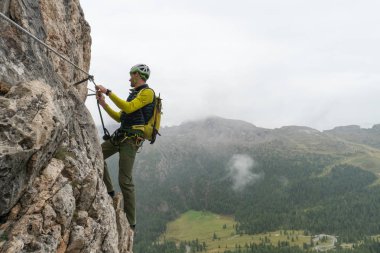 genç çekici erkek dağcı bir dik ve savunmasız Via Ferrata İtalyanca Dolomites South Tyrol Alta Badia içinde üzerinde