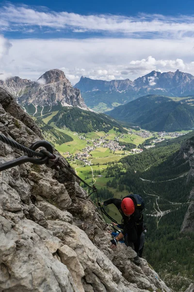 young attractive female mountain climber on a difficult Via Ferrata in the Dolomites in Alta Badia in the South Tyrol in Italy