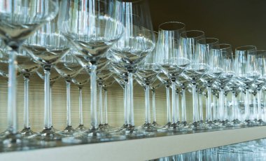 şarap gözlük sonsuz satır düzgünce bir ahşap raf restoran barda yığılmış.