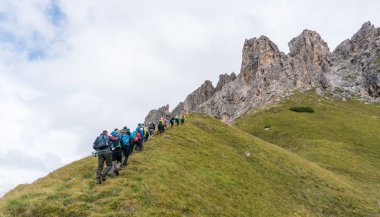 Çok sayıda dağcı ve Kuzey İtalya'daki Alta Badia Dolomites içinde bir tırmanış başlangıcı doğru hiking iki dağ rehberleri