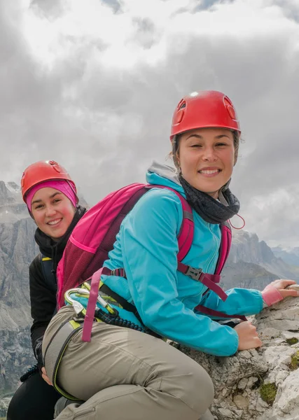 two young attractive female mountain climbers on a steep and exposed Via Ferrata in Alta Badia in the South Tyrol in the Italian Dolomites